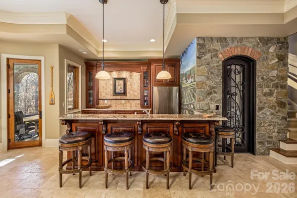 a dining hall with stainless steel appliances kitchen island a table and chairs