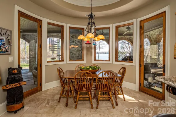 a view of a dining room with furniture large windows and wooden floor
