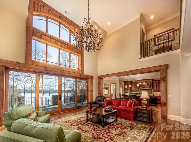 a living room with furniture a large window and a chandelier