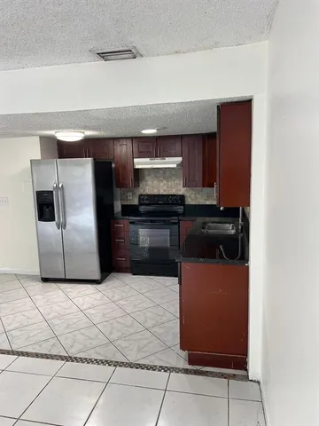 a kitchen with stainless steel appliances granite countertop a sink and a refrigerator