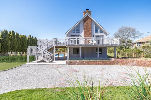 a front view of a house with a yard and potted plants