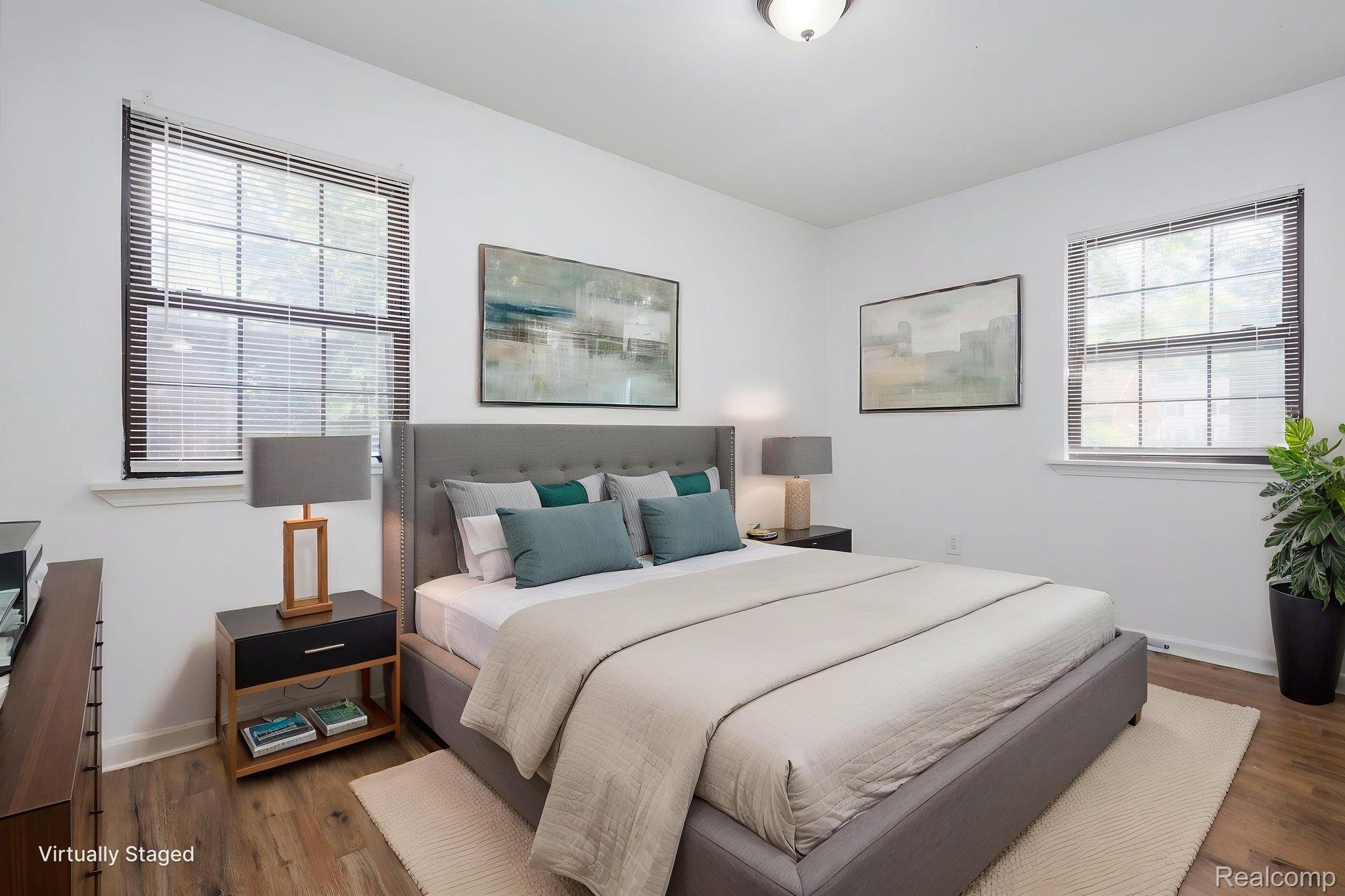 3974 Devonshire Road Detroit, MI 48224 - Photo 11 of 15 Spacious bedroom featuring wood-finish flooring, white walls, and dual double-pane windows with blinds