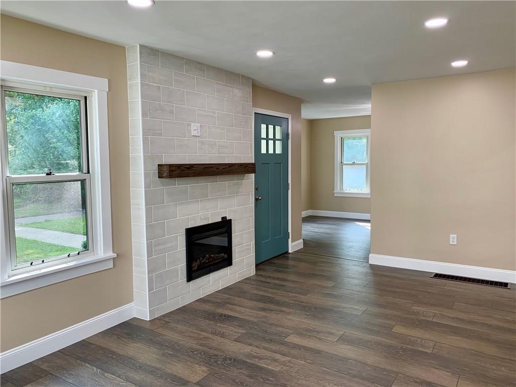 401 Bechman Street Springdale, PA 15144 - Photo 4 of 25 19x11 Living Room! New Flooring, Recessed Lighting, Baseboard, Trim, Entry Door, Ceramic Tile Fireplace with electric Fireplace Insert and Oak Mantle!