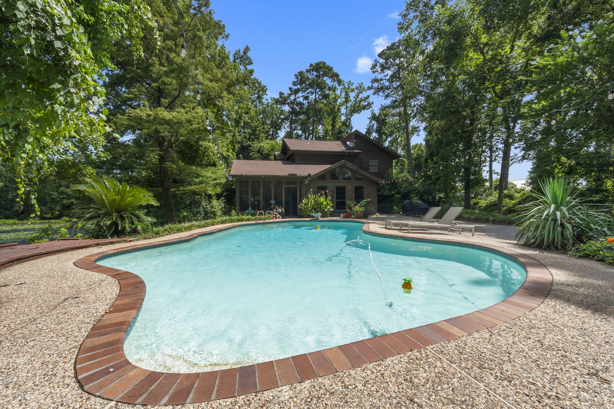 426 Nursery Road The Woodlands, TX 77380 - Photo 18 of 41 Gorgeous setting with inviting pool and custom deck with seating. String lights are great for atmosphere located at main house #426.