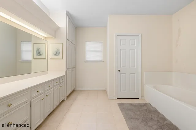 a bathroom with a tub sink and mirror