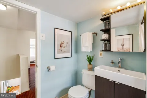 a bathroom with a toilet sink and mirror