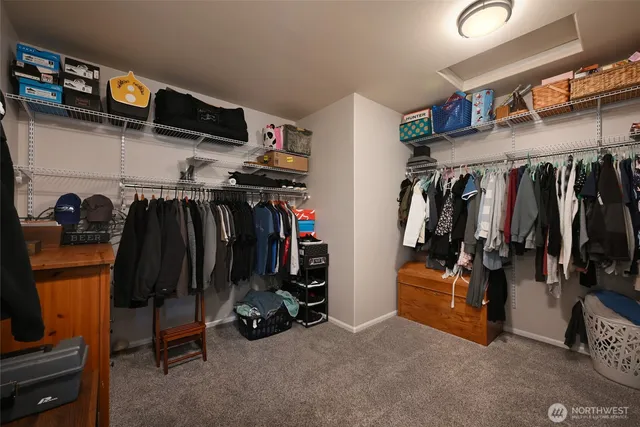 a view of walk in closet with clothes and shoes