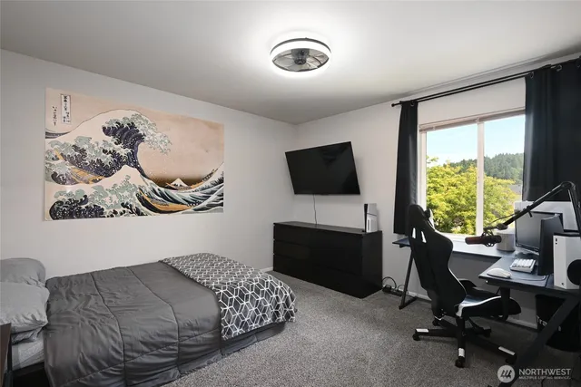 a bedroom with furniture and a flat screen tv