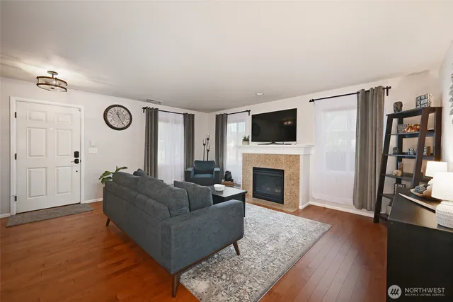 a living room with furniture a fireplace and a flat screen tv