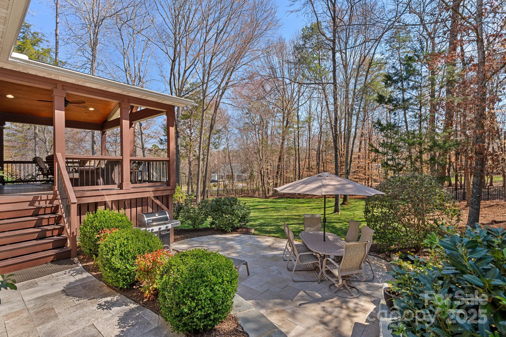 105 Elizabeth Brook Drive Davidson, NC 28036 - Photo 31 of 43 a view of a patio with a table and chairs under an umbrella with a garden