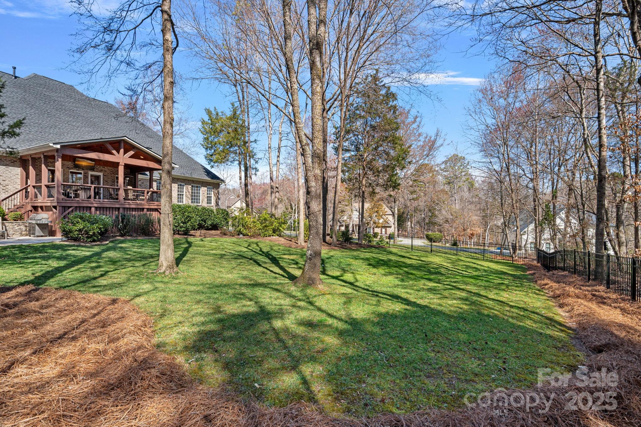 105 Elizabeth Brook Drive Davidson, NC 28036 - Photo 34 of 43 a view of a big yard in front of a brick house with large windows