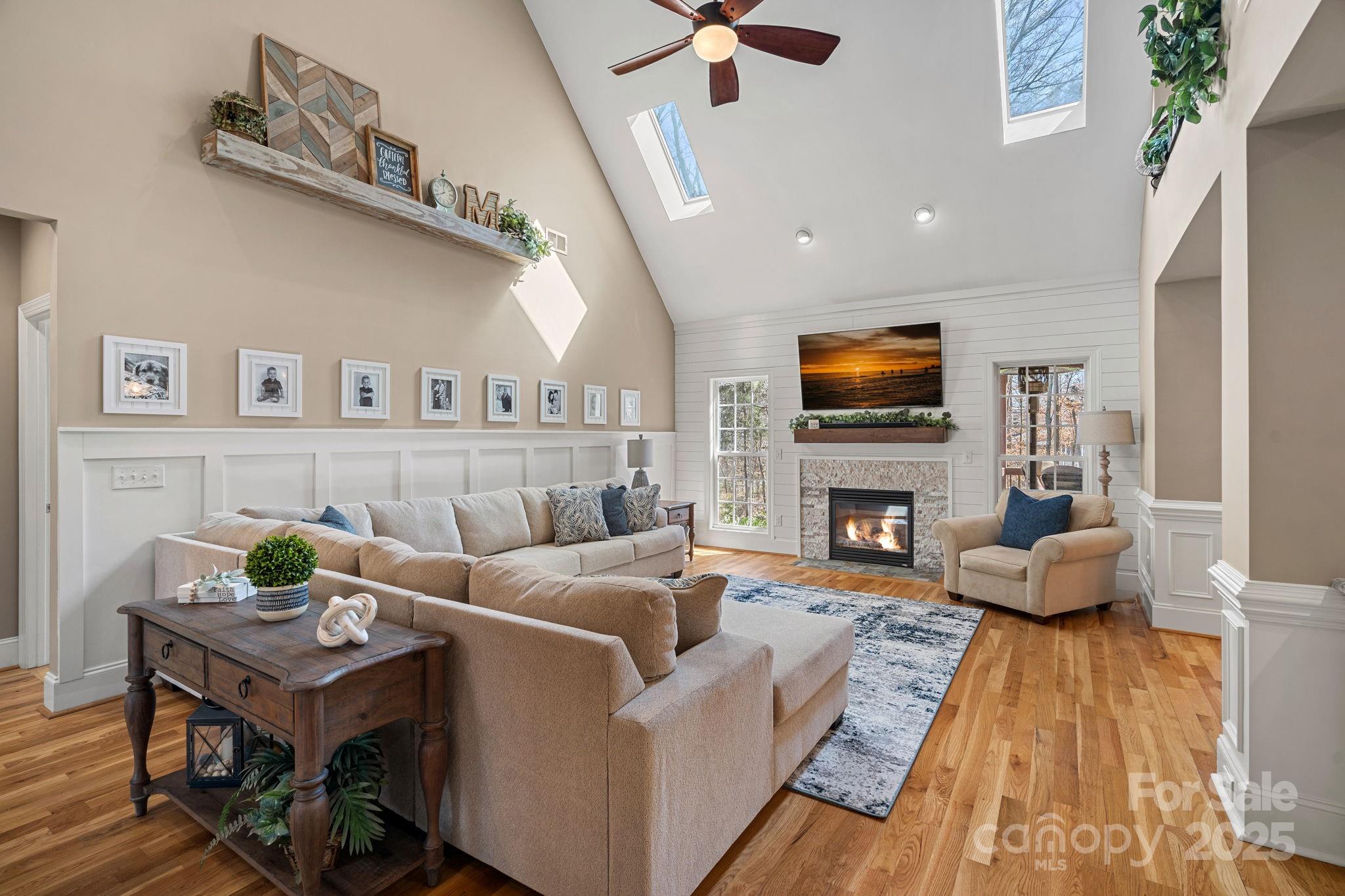 105 Elizabeth Brook Drive Davidson, NC 28036 - Photo 5 of 43 a living room with furniture a fireplace and a flat screen tv