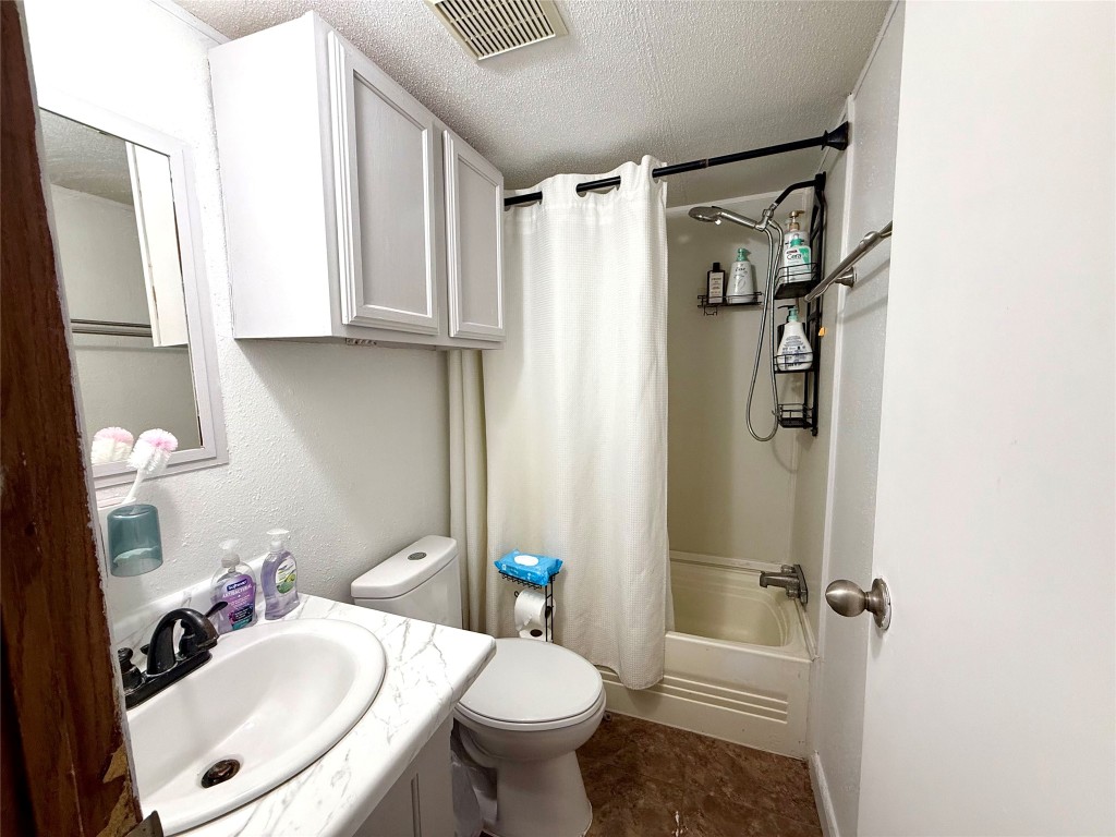 685 Fox Lane Lockhart, TX 78644 - Photo 27 of 39 Bathroom with a textured ceiling, shower / tub combo, and double vanity