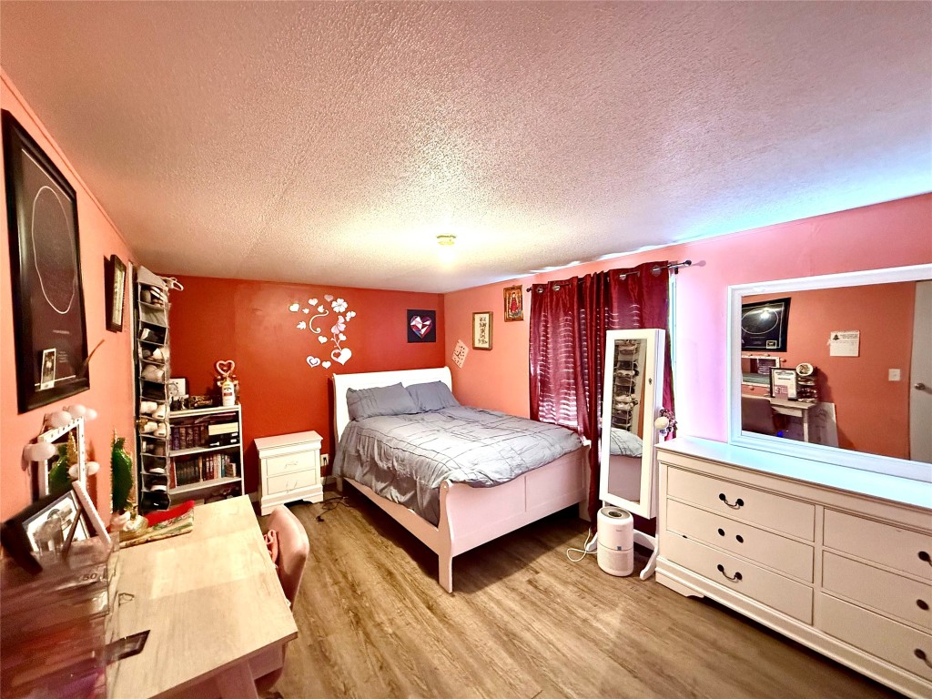 685 Fox Lane Lockhart, TX 78644 - Photo 28 of 39 Bedroom with a textured ceiling and light wood-type flooring