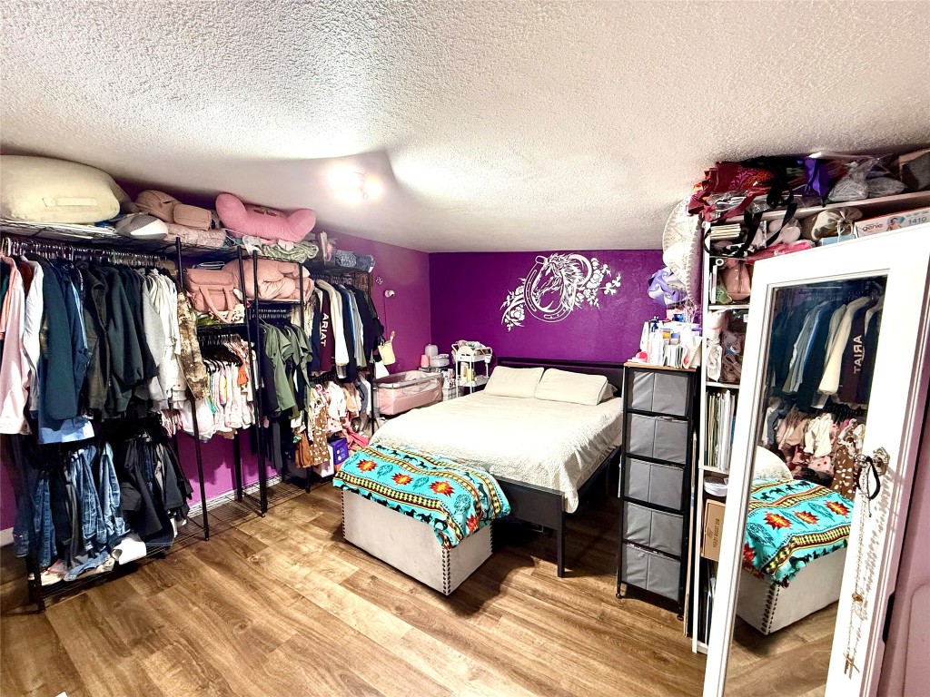 685 Fox Lane Lockhart, TX 78644 - Photo 29 of 39 Bedroom featuring wood finished floors, a textured ceiling, and a closet. Extra added room