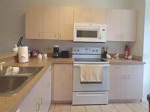 a kitchen with white cabinets and white appliances