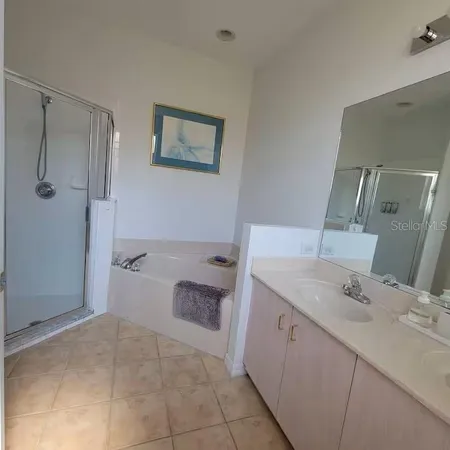 a spacious bathroom with a tub sink and mirror