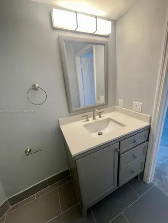 a utility room with a sink a mirror and vanity