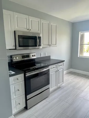 a kitchen with stainless steel appliances granite countertop a stove a microwave and a sink