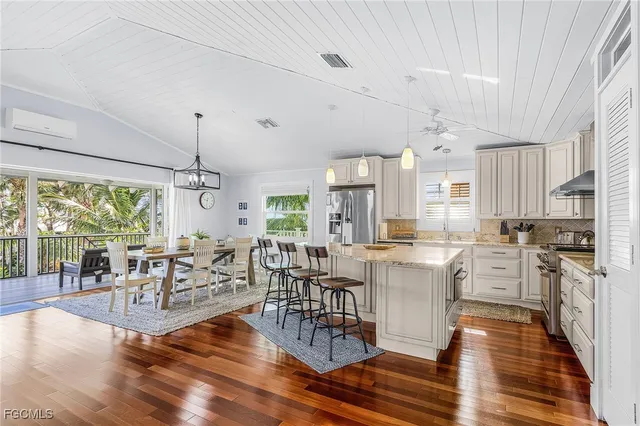 a living room with lots of furniture wooden floor and a chandelier