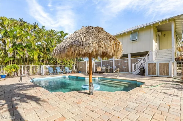 a patio with a yard and palm trees