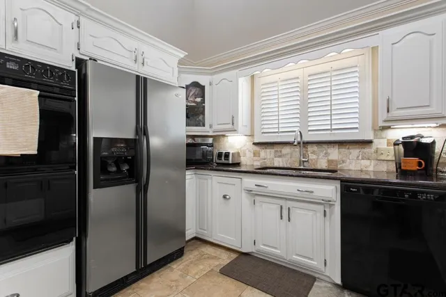 a kitchen with stainless steel appliances granite countertop a refrigerator and a sink