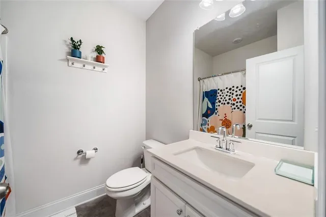 a bathroom with a sink vanity mirror and toilet