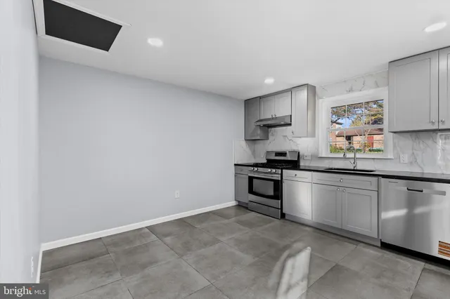 a kitchen with granite countertop white cabinets and stainless steel appliances