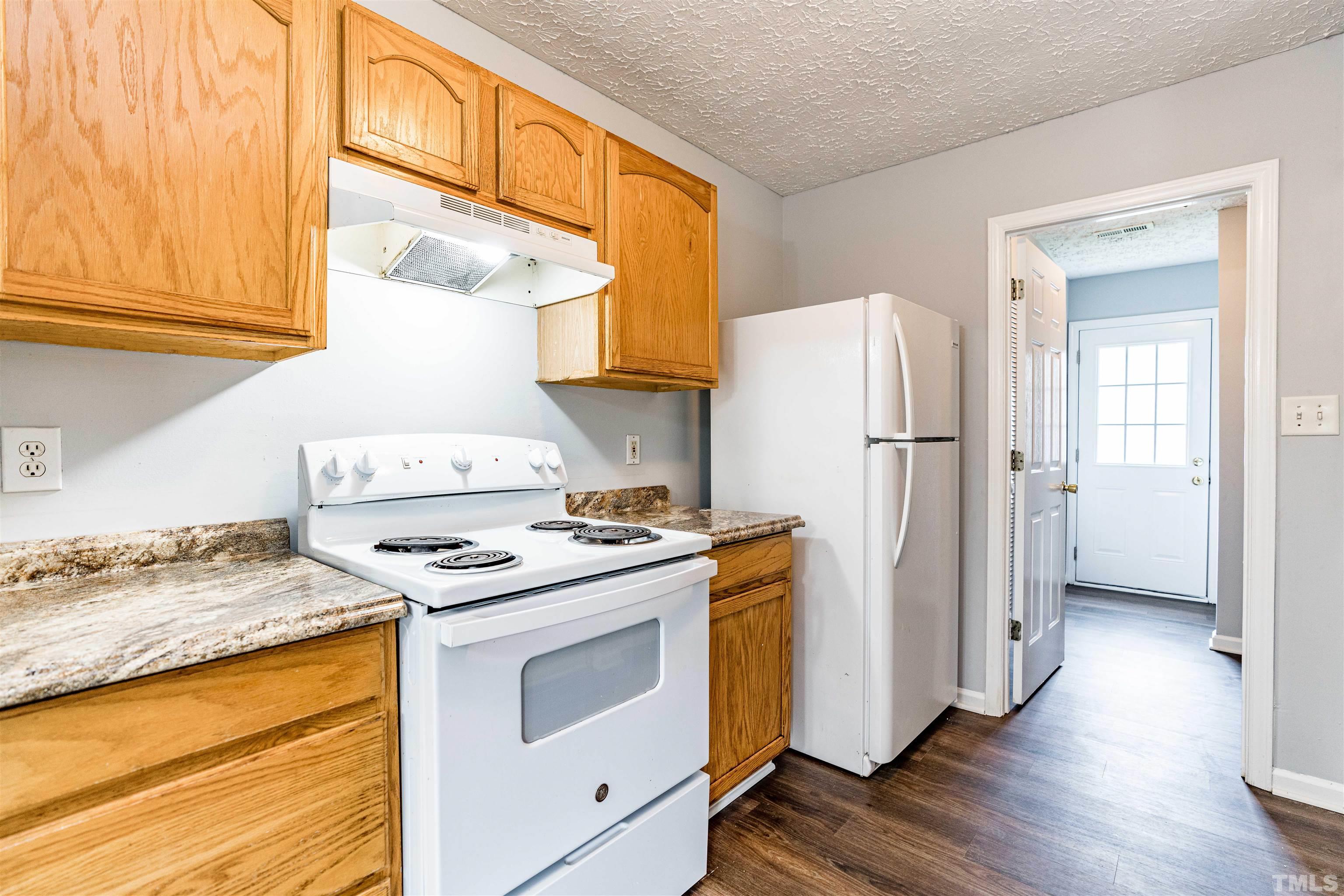 3208 Slippery Elm Drive Raleigh, NC 27610 - Photo 11 of 24 a kitchen with a stove a refrigerator and a stove