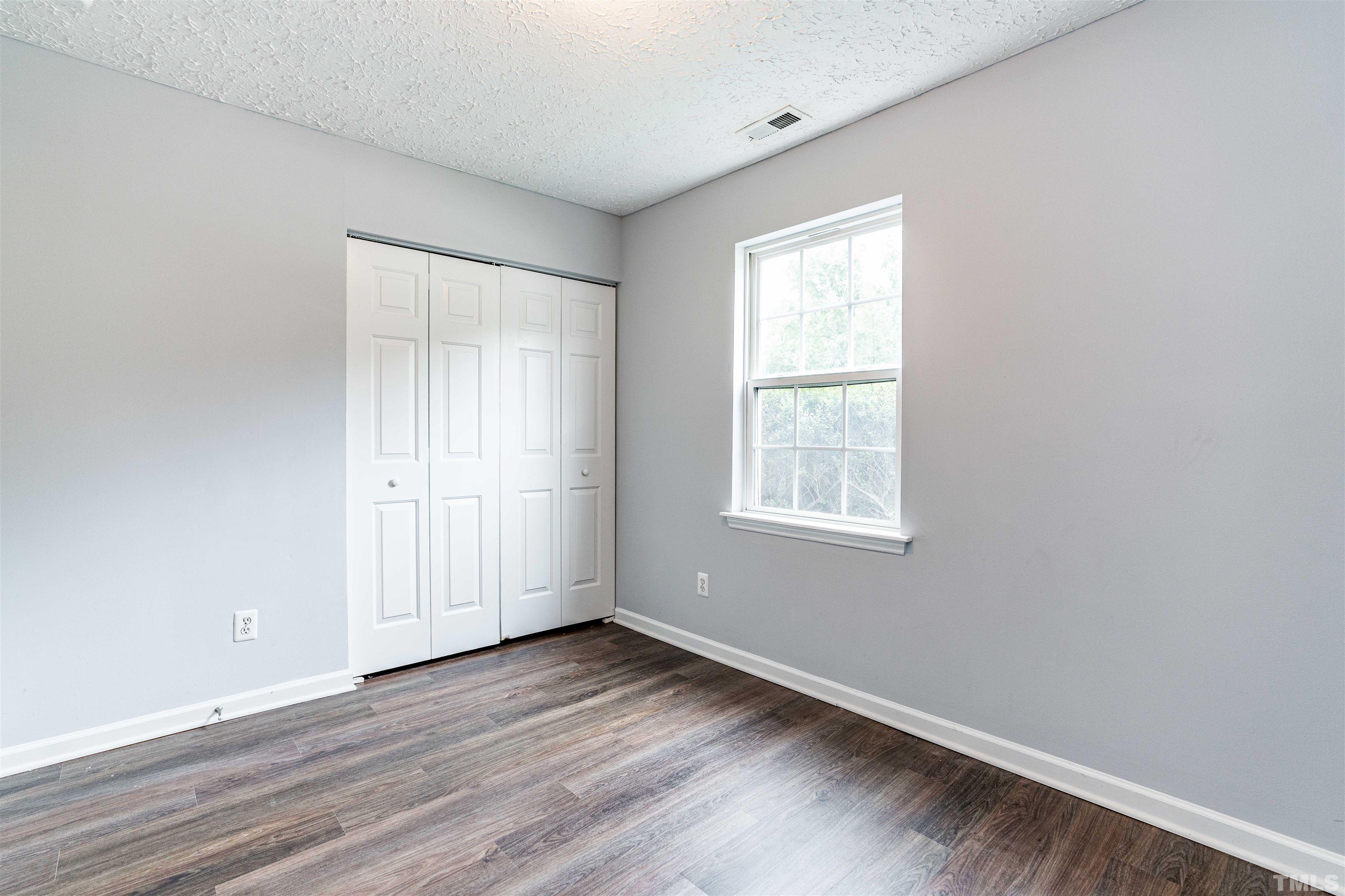 3208 Slippery Elm Drive Raleigh, NC 27610 - Photo 15 of 24 an empty room with wooden floor and windows