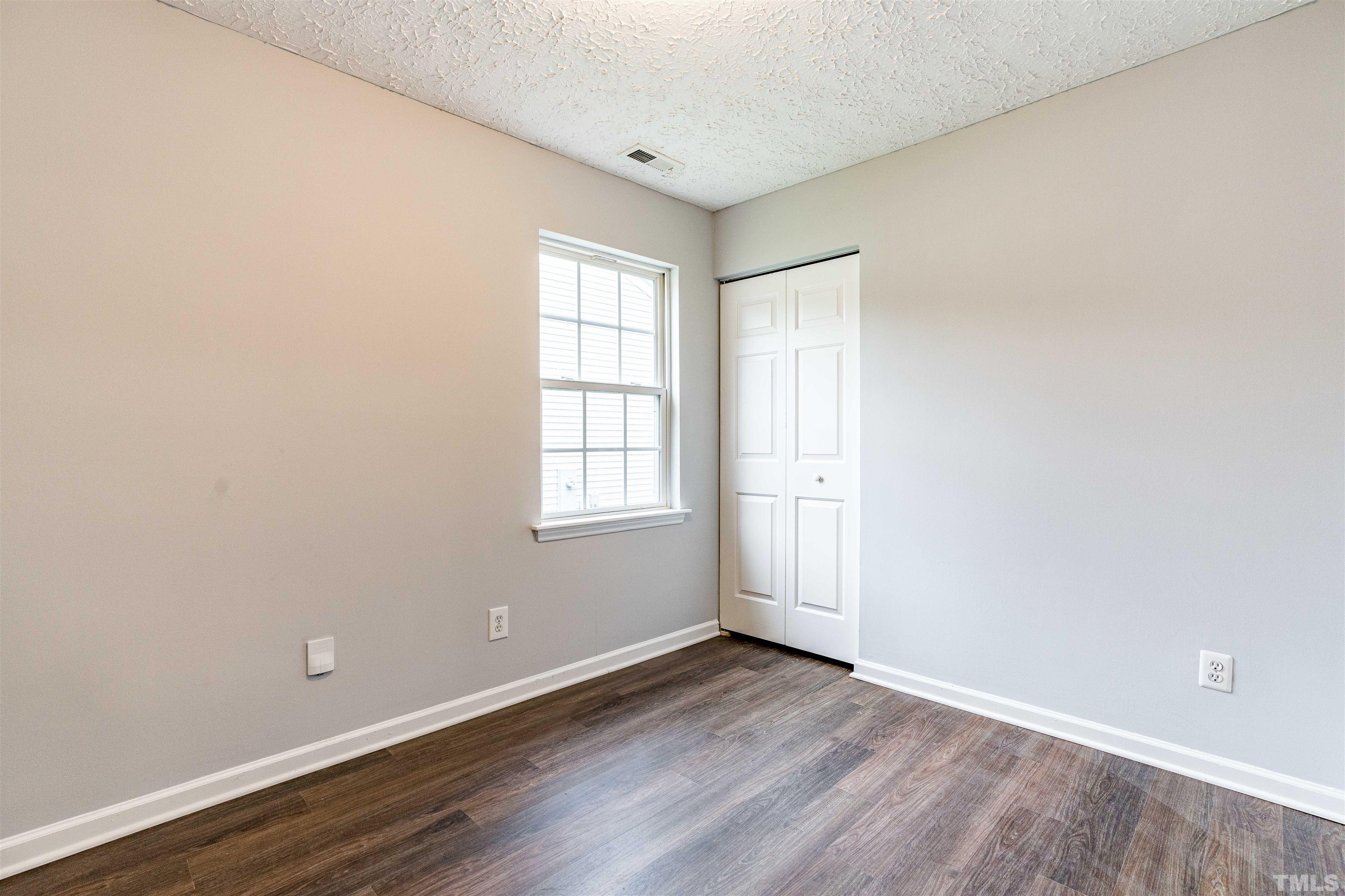 3208 Slippery Elm Drive Raleigh, NC 27610 - Photo 16 of 24 an empty room with wooden floor and windows