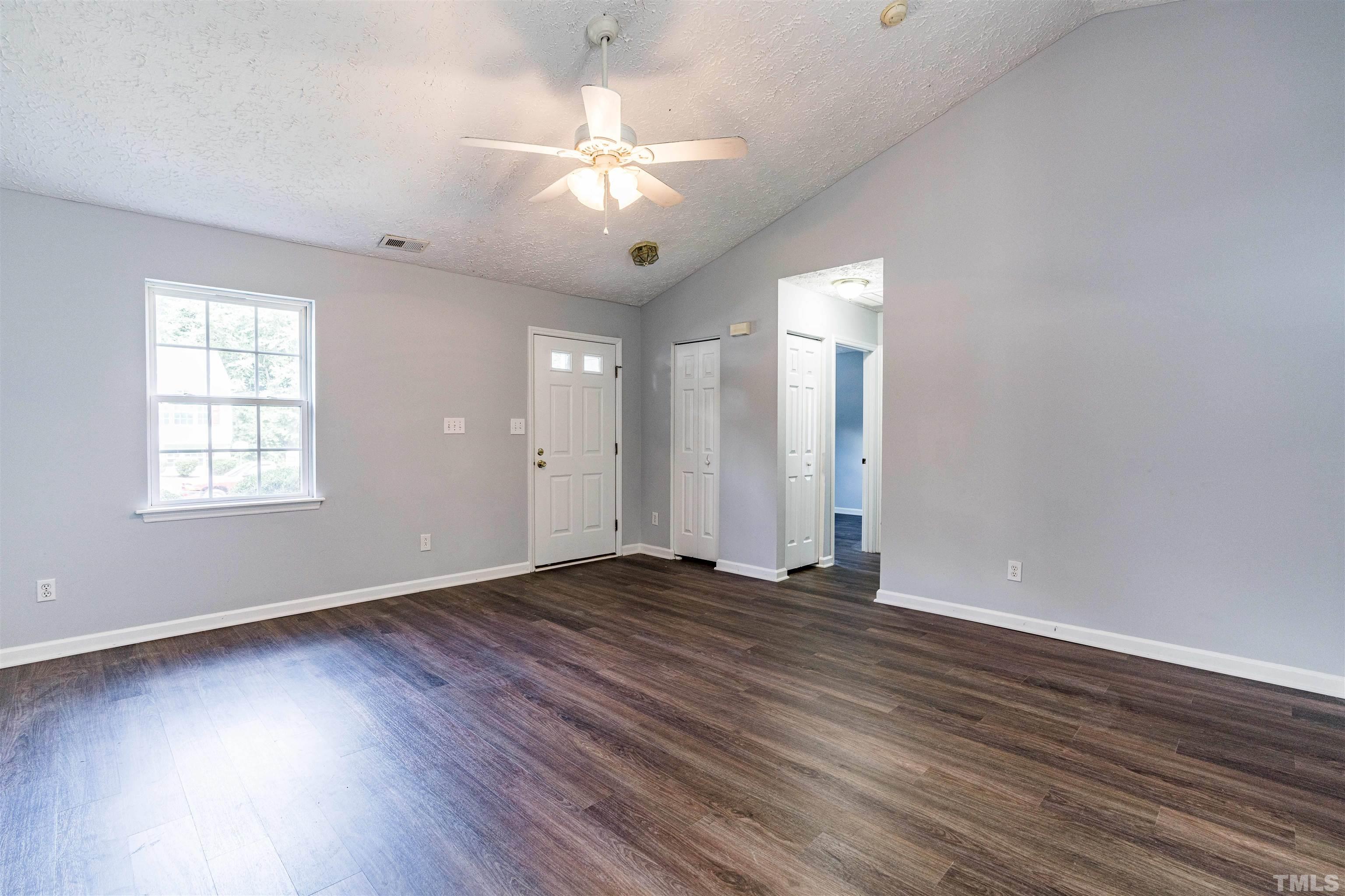 3208 Slippery Elm Drive Raleigh, NC 27610 - Photo 4 of 24 an empty room with wooden floor and windows
