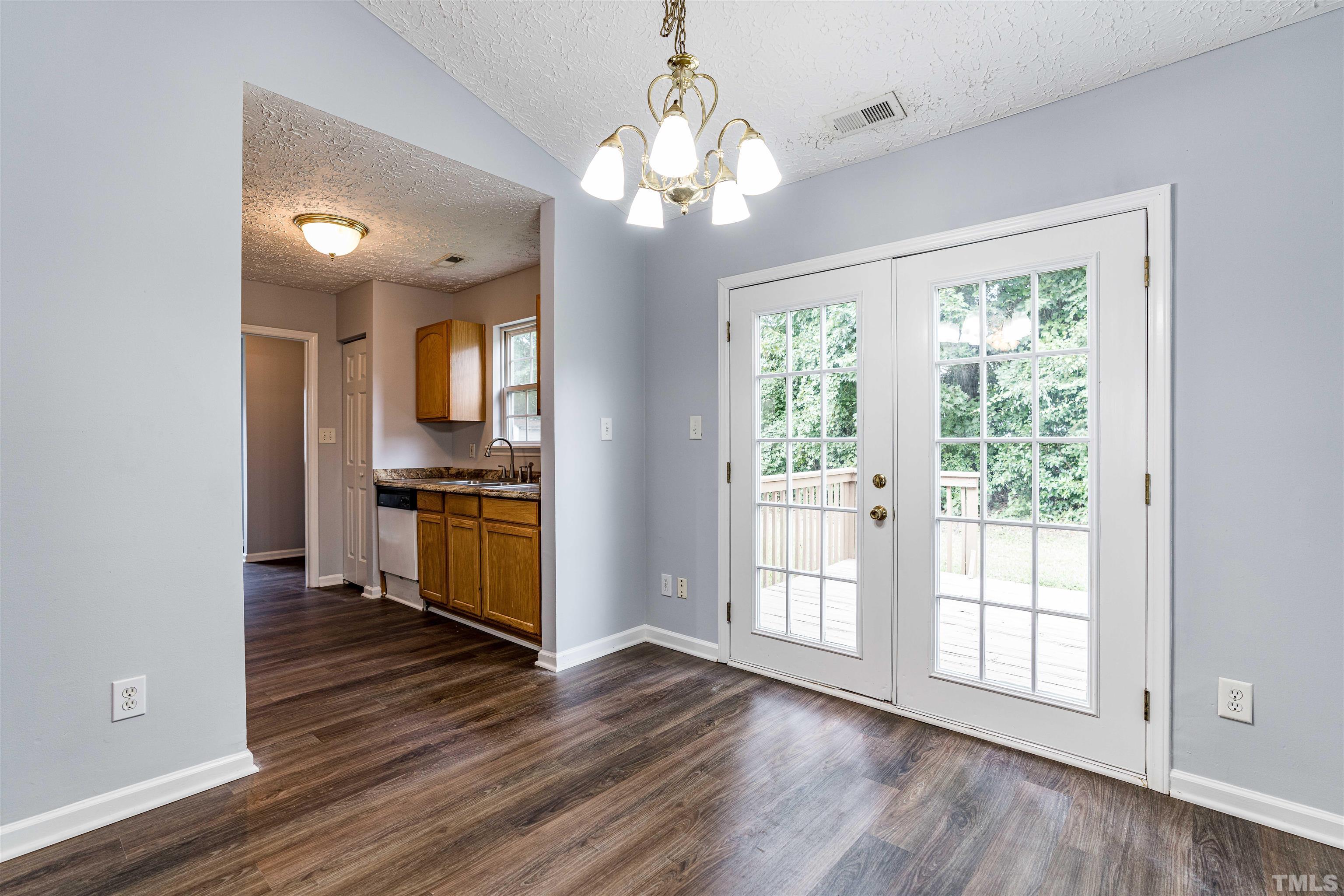 3208 Slippery Elm Drive Raleigh, NC 27610 - Photo 7 of 24 a kitchen with stainless steel appliances granite countertop a stove top oven a sink with wooden floors and cabinets
