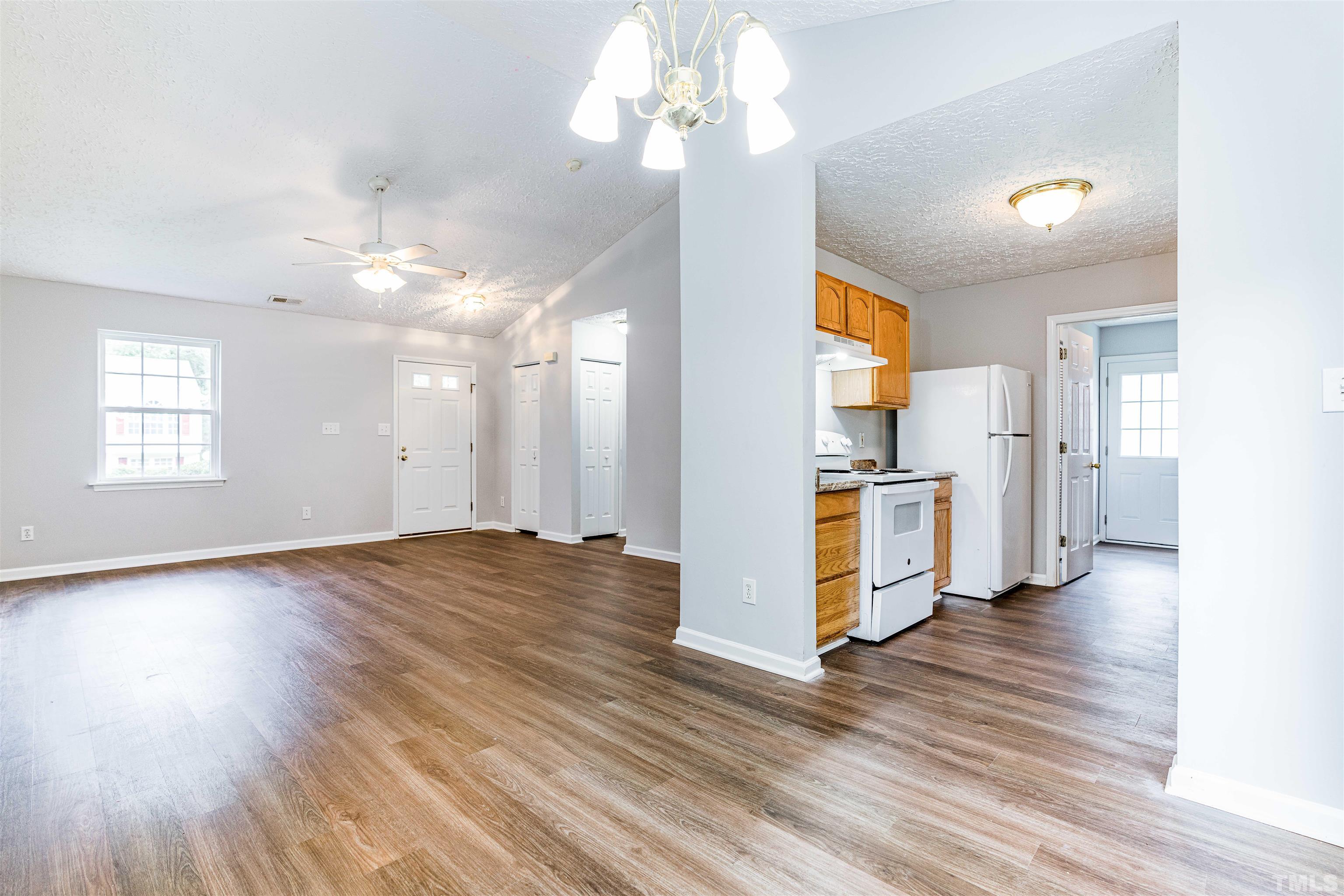 3208 Slippery Elm Drive Raleigh, NC 27610 - Photo 8 of 24 a view of a kitchen with wooden floor and a ceiling fan