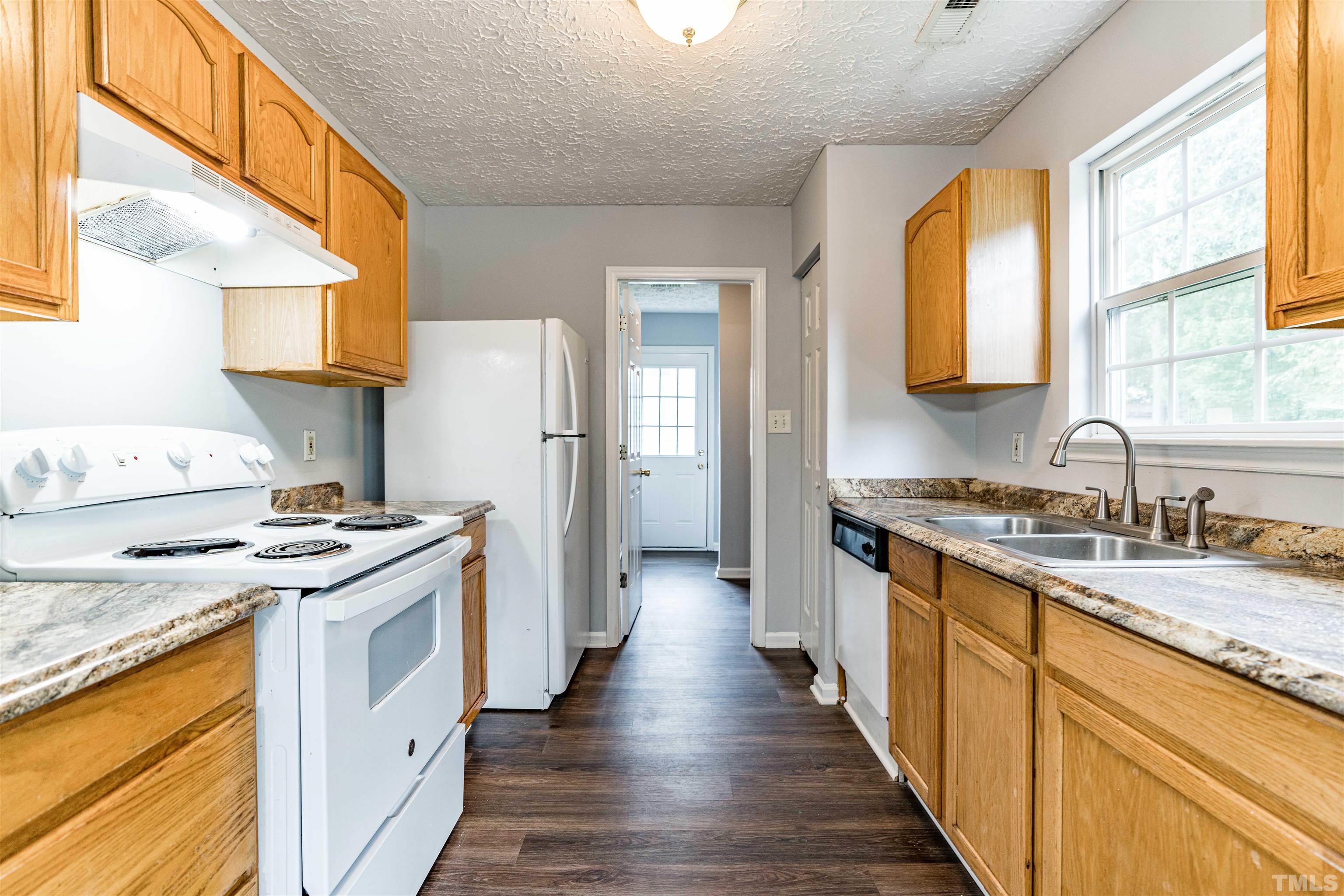 3208 Slippery Elm Drive Raleigh, NC 27610 - Photo 9 of 24 a kitchen with granite countertop a sink stove and refrigerator