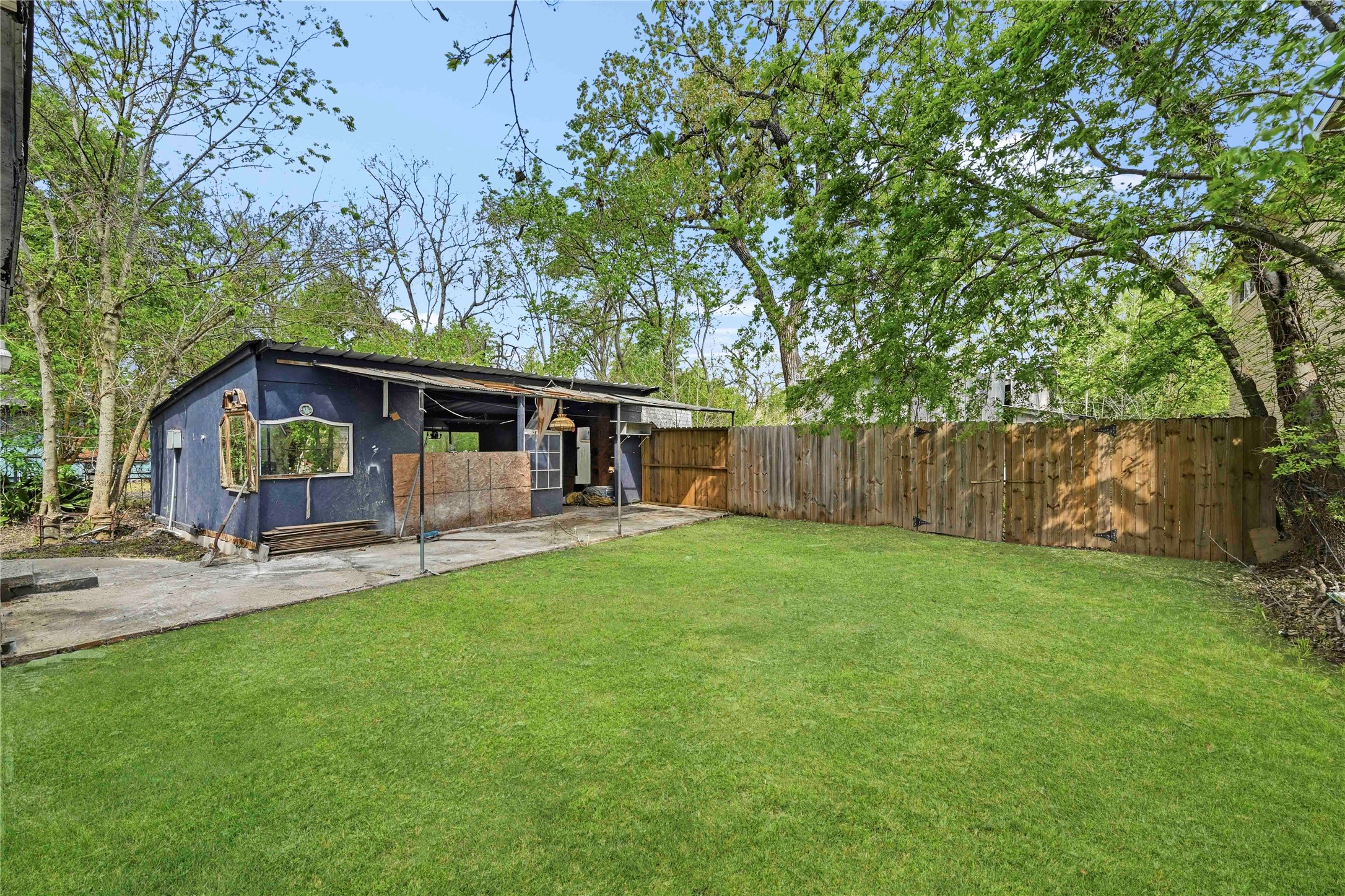 5513 Makeig Street Houston, TX 77026 - Photo 30 of 33 This property features a spacious yard with mature trees, a fenced area for added privacy, and a covered outdoor structure offering flexible outdoor space.