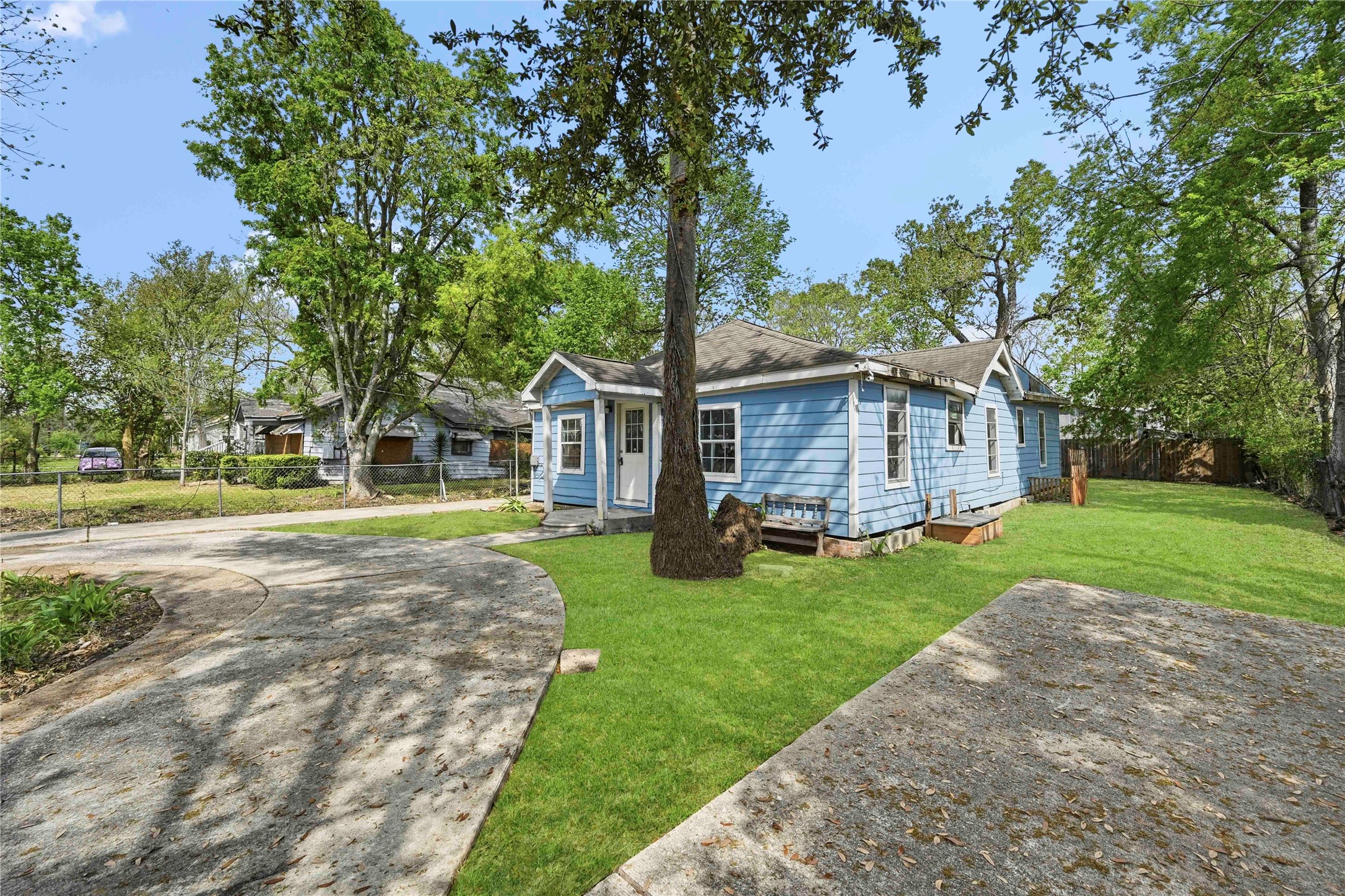 5513 Makeig Street Houston, TX 77026 - Photo 31 of 33 Single story home with a spacious front yard, mature trees, and a curved driveway, creating a welcoming and inviting entrance.