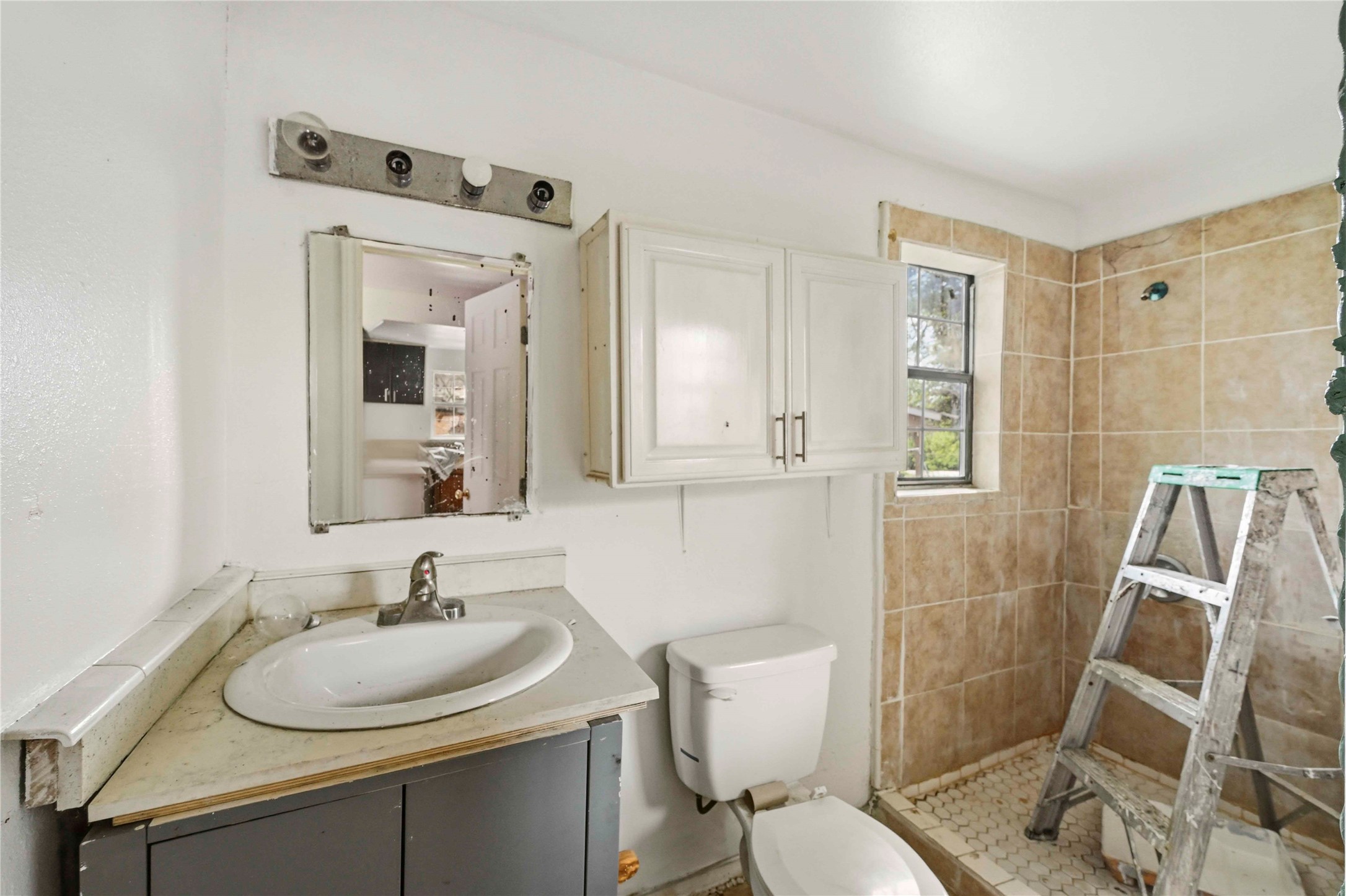 5513 Makeig Street Houston, TX 77026 - Photo 5 of 33 This bathroom features a simple and functional layout with natural light from a small window and tiled accents in the shower area. A great opportunity to refresh and create a calm and comfortable space.