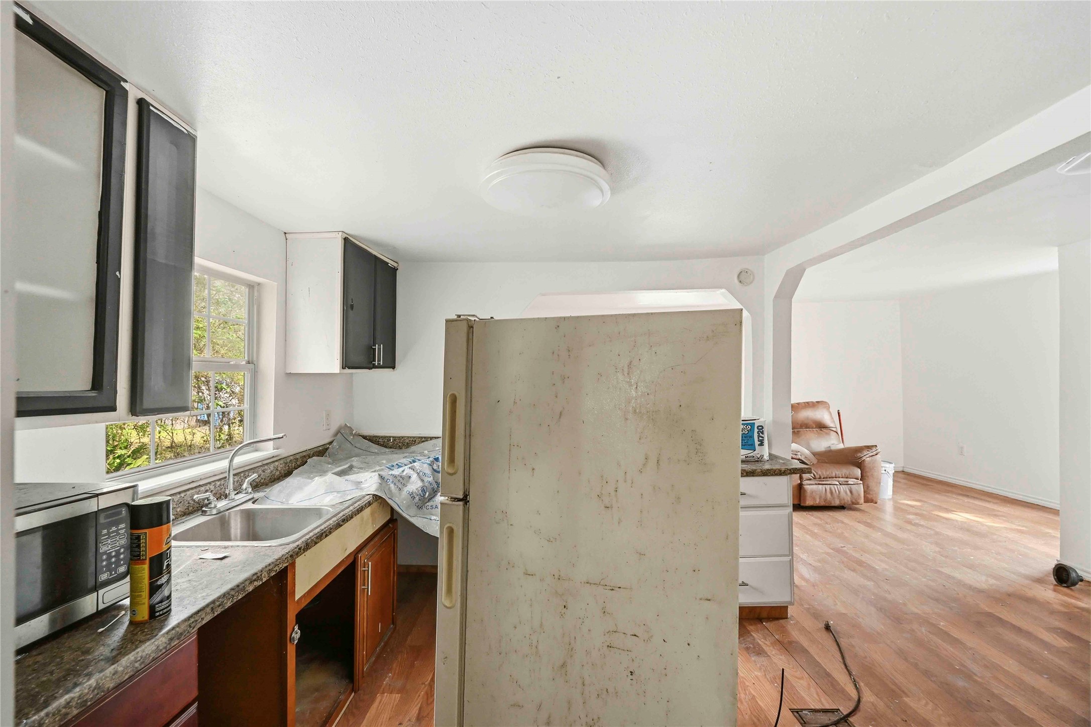 5513 Makeig Street Houston, TX 77026 - Photo 10 of 33 Natural light from the window brightens this kitchen, which features hardwood floors, a double sink, and an open flow into the living area. A wonderful opportunity to update and design a space that fits your style.