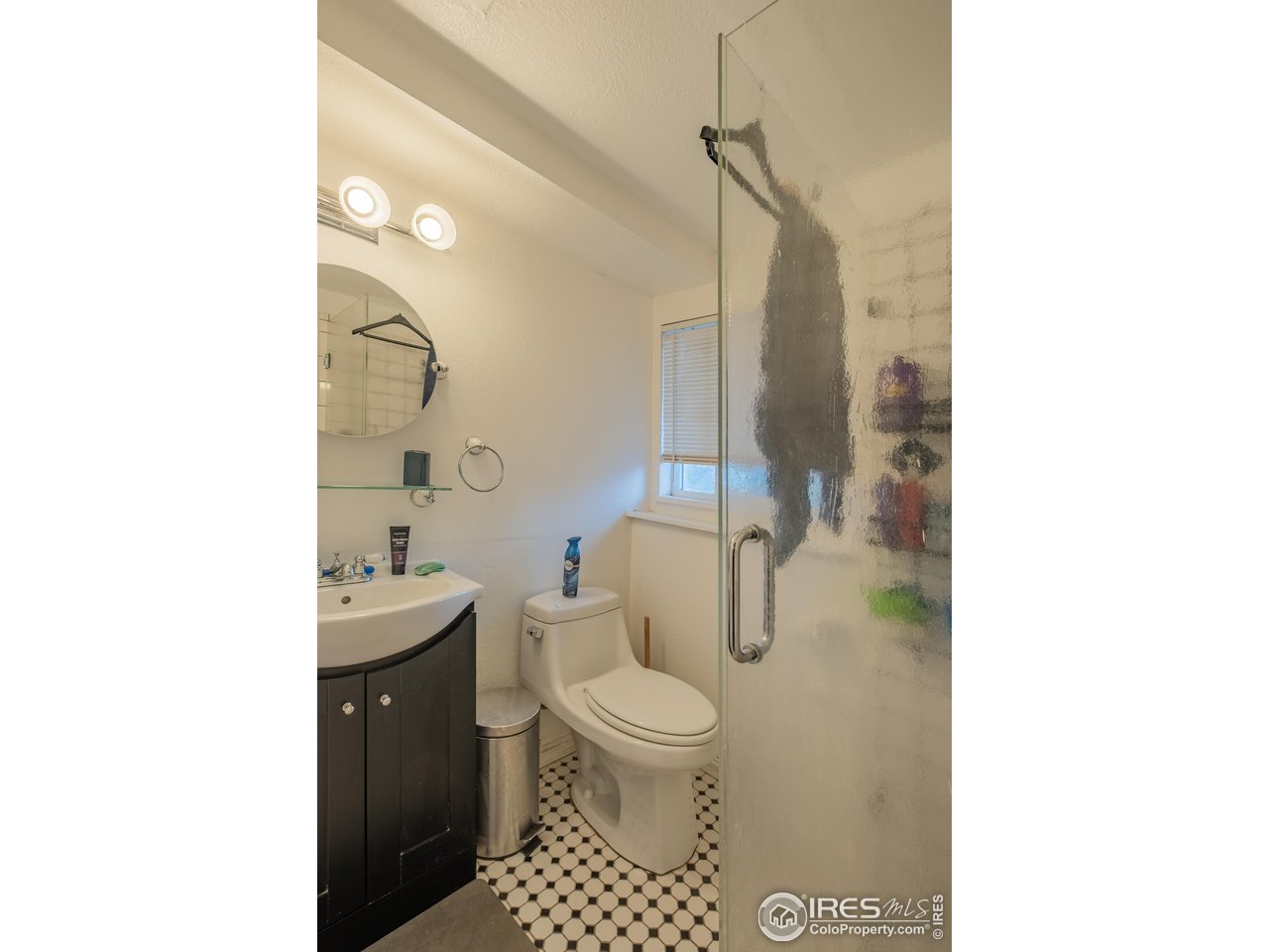1602 29th Avenue Greeley, CO 80634 - Photo 11 of 18 a bathroom with a toilet a sink and a mirror