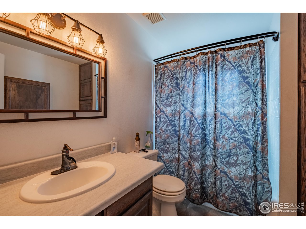 1602 29th Avenue Greeley, CO 80634 - Photo 10 of 18 a bathroom with a toilet sink and mirror