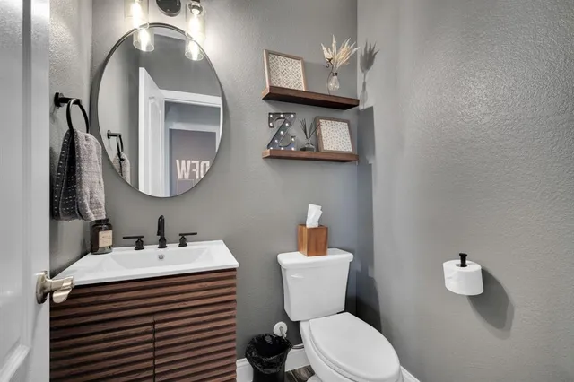 a bathroom with a sink a toilet and mirror
