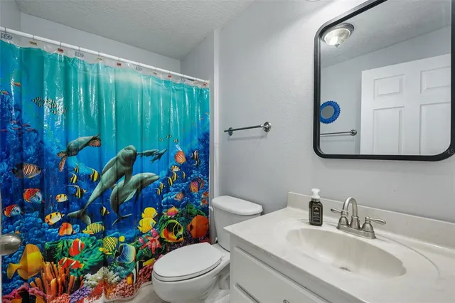 a view of a bedroom with cabinet and a ceiling fan