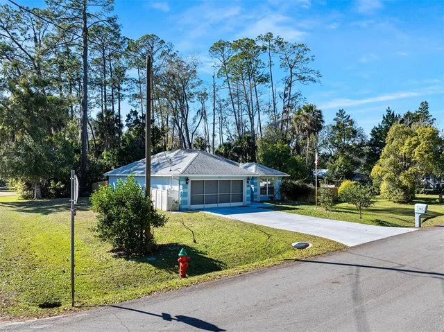 a view of a house with swimming pool and yard with trees