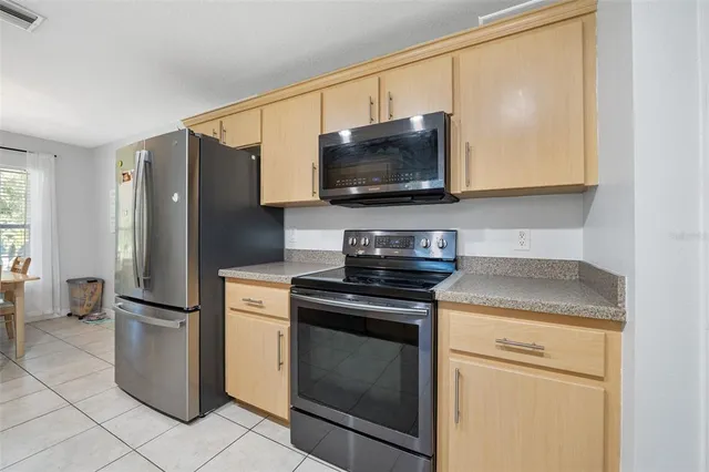 a kitchen with stainless steel appliances granite countertop a refrigerator and a sink