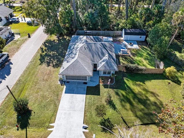 a aerial view of a house with swimming pool and large trees