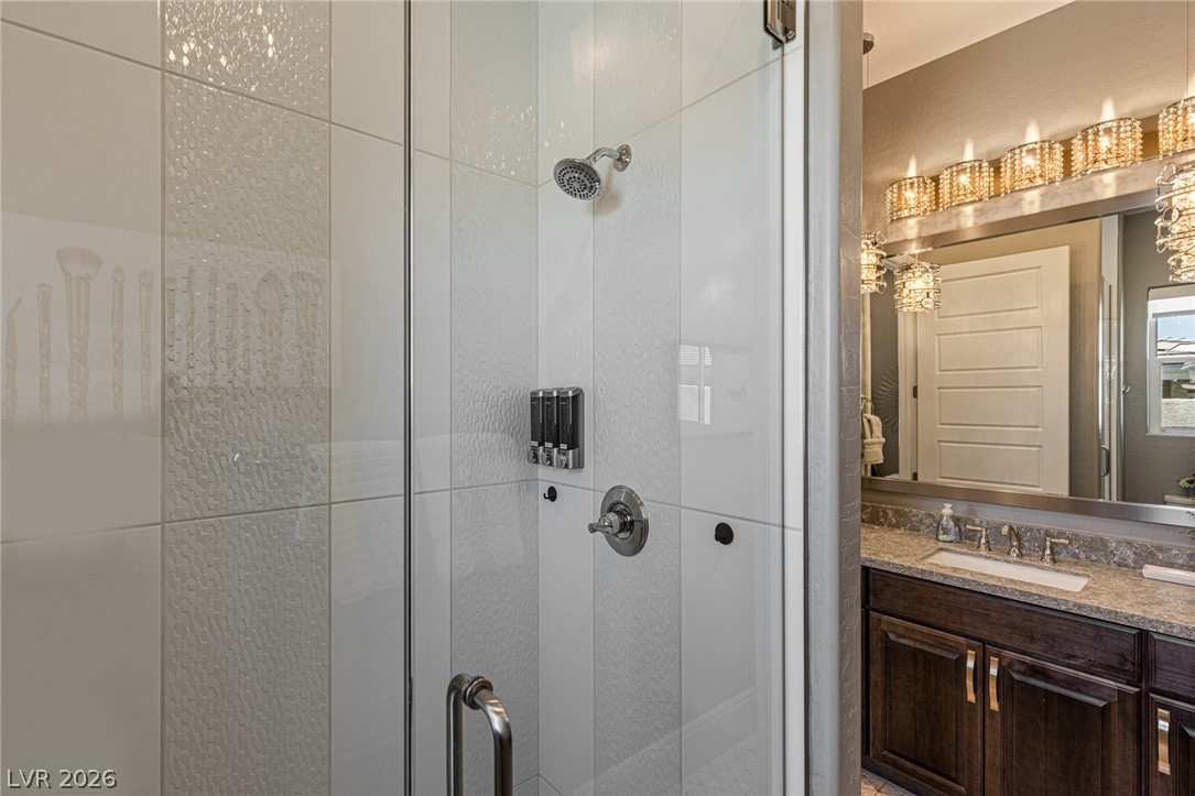 10118 Copper Edge Road Las Vegas, NV 89148 - Photo 27 of 48 A well-appointed bathroom with a spacious glass-enclosed shower and modern vanity lighting.
