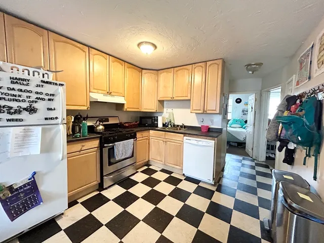a kitchen with a checkered floor and white cabinets