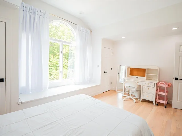 a spacious bedroom with a bed and a large window