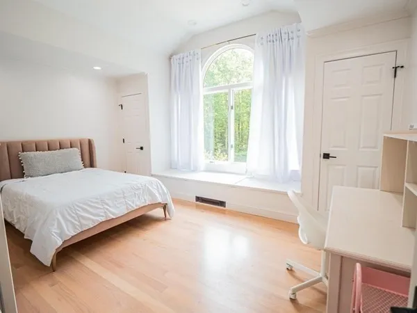 a bedroom with a bed and a large window